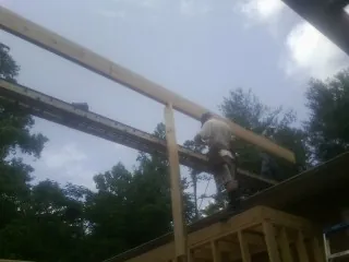 Carpenter setting a ridge beam over a new addition frame — Ice Dam Removal by Roofing Brothers in Donnelly