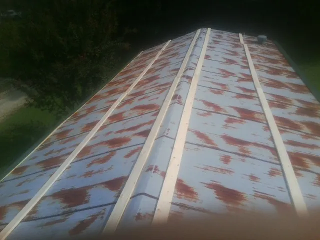 Rusted metal roof panels with new wood purlins before replacement — Storm Damage Roof Repair in Donnelly by Roofing Brothers