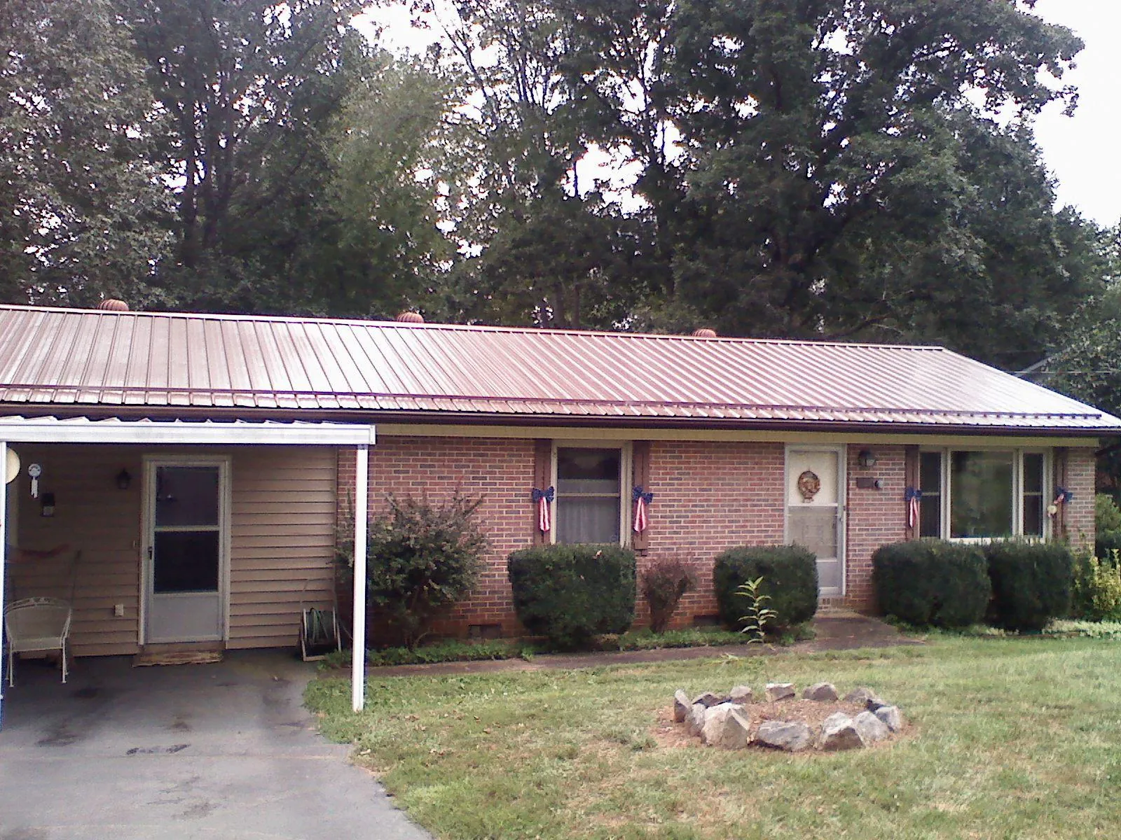 Bronze metal roof and carport on a brick ranch home — Roof Repair work by our crew in Donnelly